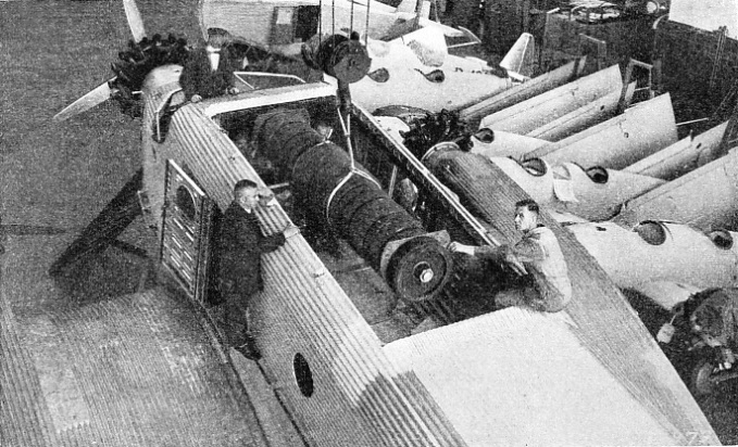 LOADING MACHINERY THROUGH THE HATCHWAY in the fuselage of a Junkers G-31 monoplane